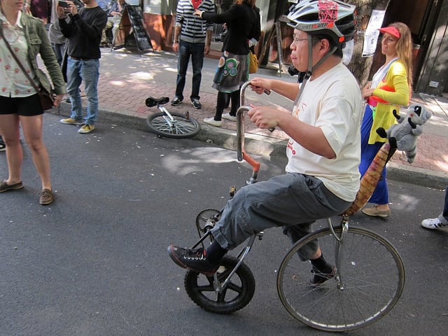 A man rides a very little bike at Bike Fetish Day