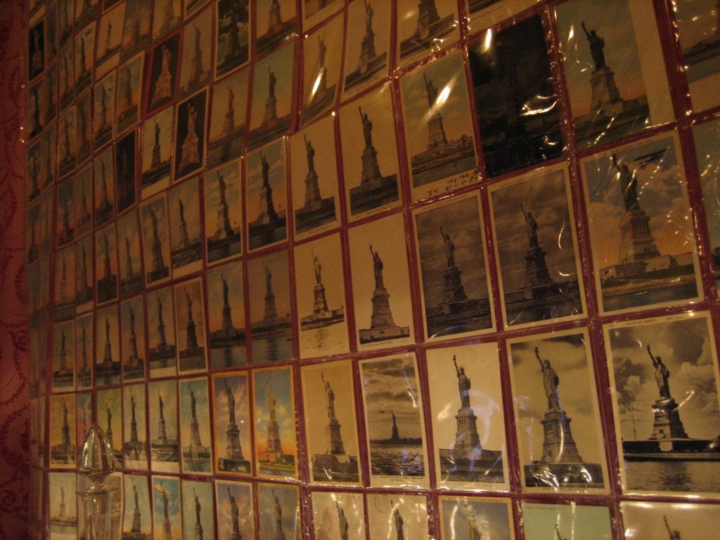 Wall of postcards featuring the Statue of Liberty at the City Reliquary