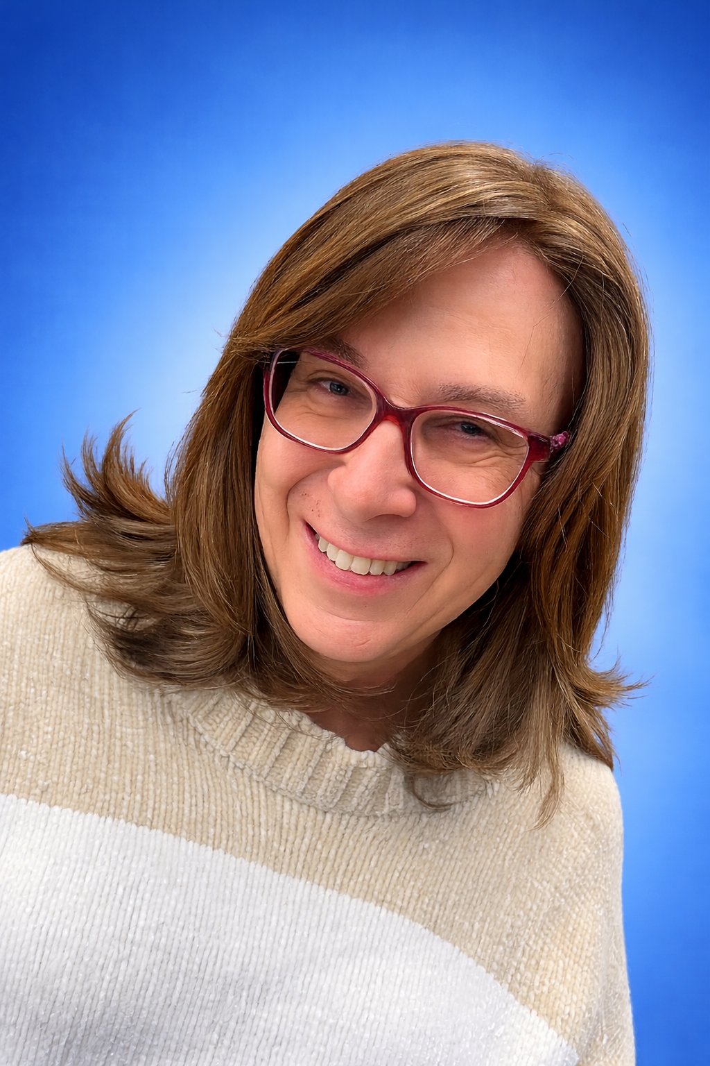 Bernie Wagenblast in a cream and brown sweater in front of a blue background