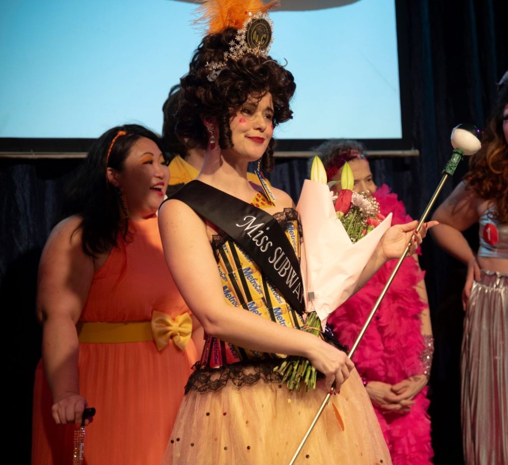 Bimini Cricket, in a yellow gown with a subway design, sash, and crown.