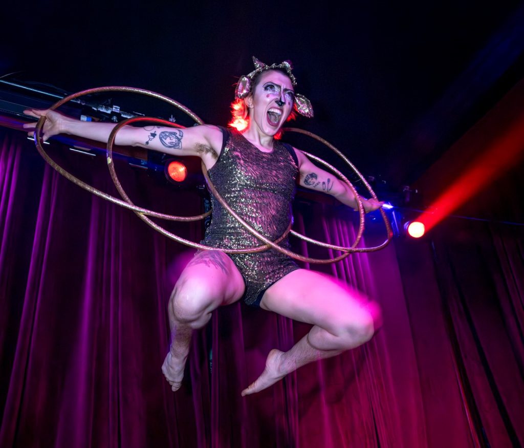 Sugar Hoops, leaping in the air and holding three circus hoops
